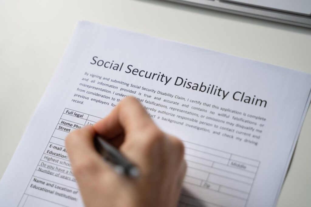 Close up of hand holding pen about to fill out form for Social Security Disability Claim